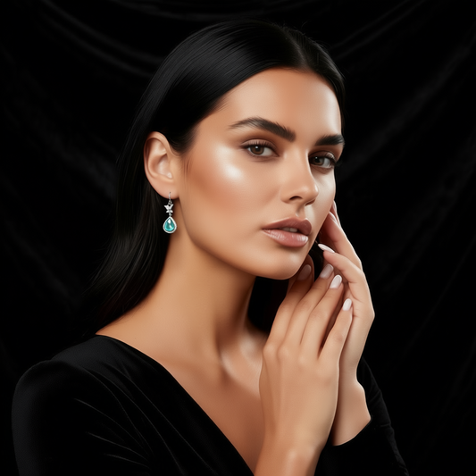 Detail of Metamorphosis earrings showing green tourmaline stone and butterfly design element